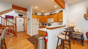 A kitchen with wooden cabinets, a microwave, and a coffee maker. There is a fire extinguisher mounted on the wall. - Cozy Dog Friendly Retreat w/ Hot Tub & Views (McHenry)