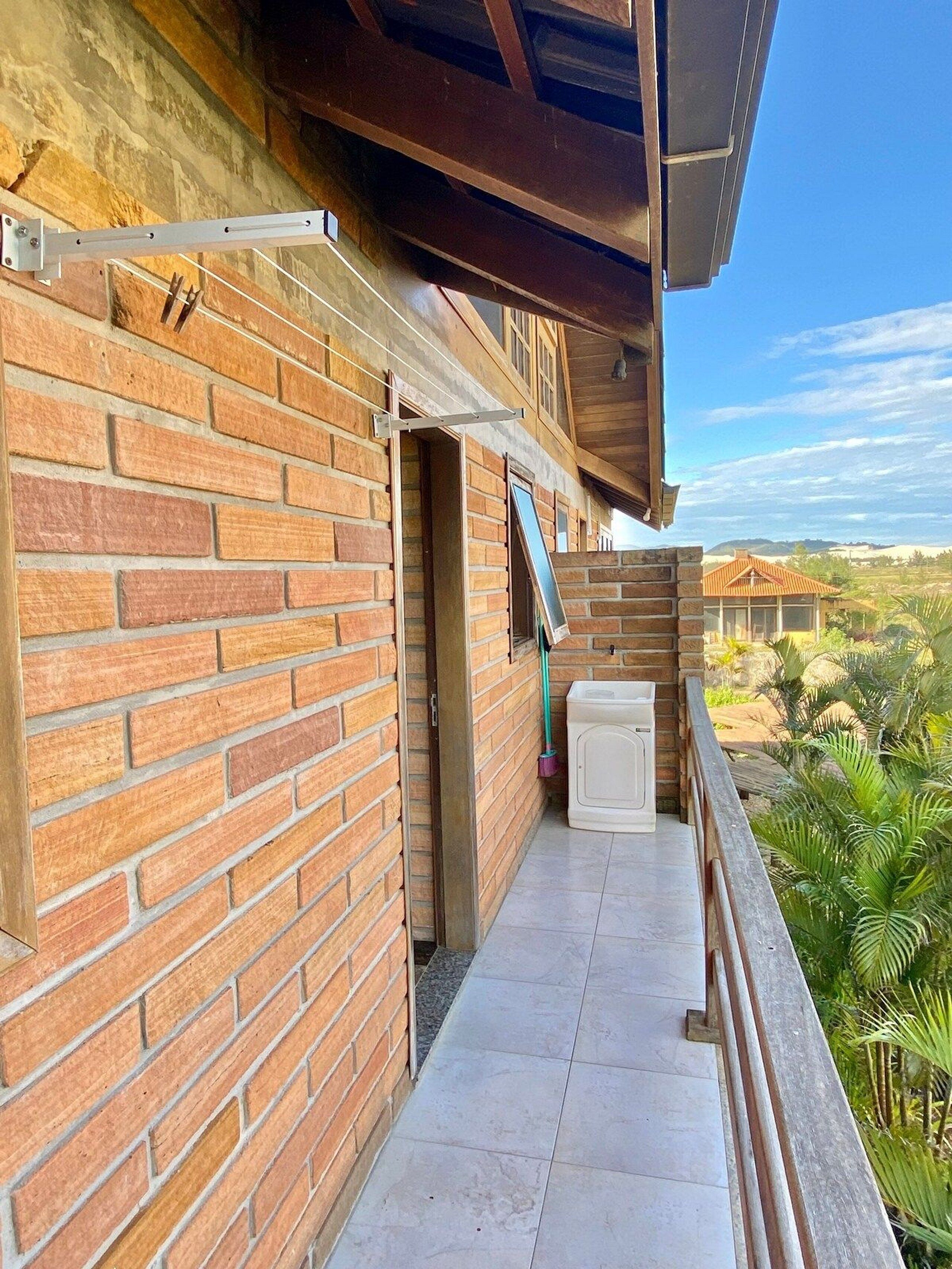Facciata in mattoni con un balcone, una finestra e vista sul paesaggio.