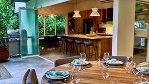 Una cocina moderna con armarios de madera, una isla central y lámparas colgantes.