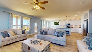 A spacious living room with two sofas, a coffee table, and a ceiling fan. - 7 Day Weekend: 4  BR, 3  BA House in Crystal Beach, Sleeps 17 (Bolivar Peninsula)