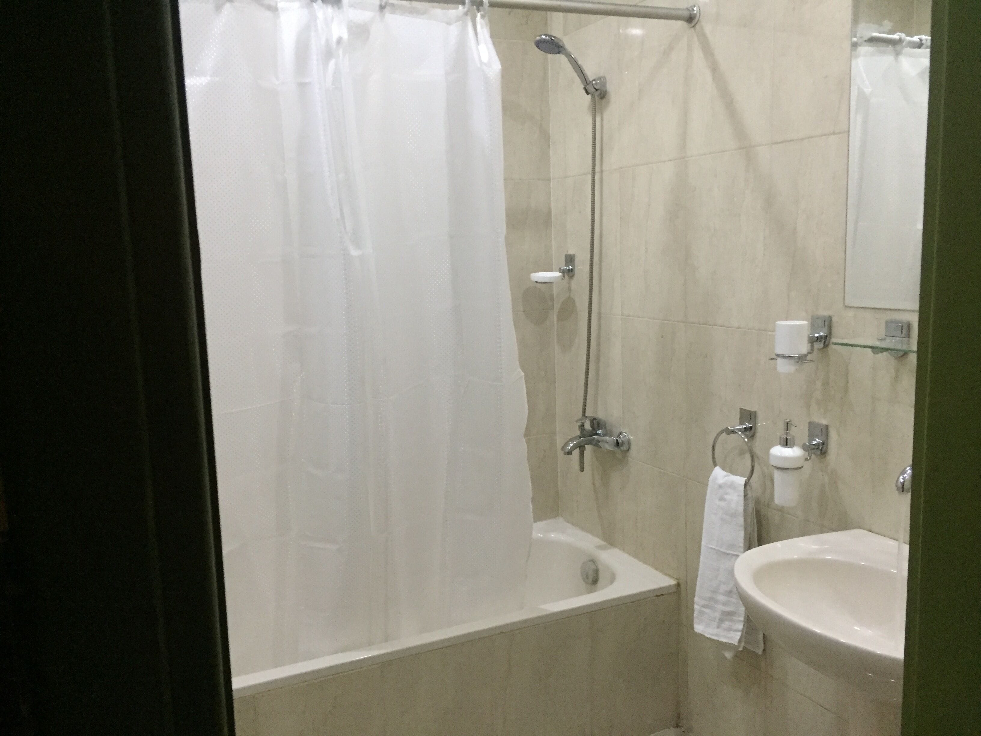 A bathroom with a bathtub, a shower, a sink, and a mirror.
