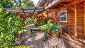 Une cabane en bois dotée d’un porche abrité, de plantes en pot et d’une fenêtre.