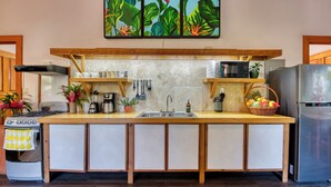 Une cuisine dotée d’un îlot central, d’une cuisinière, d’un four à micro-ondes et d’un réfrigérateur.