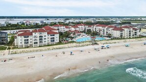 Een kusthotel met meerdere gebouwen, een strand en een zwembad.