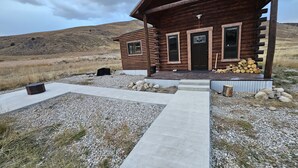 A wooden cabin with a porch, a gravel driveway, and a mountainous backdrop. - Reboot, Recover, Recreate…Centrally located 20 acre Mill Creek getaway cabin! (Anaconda)