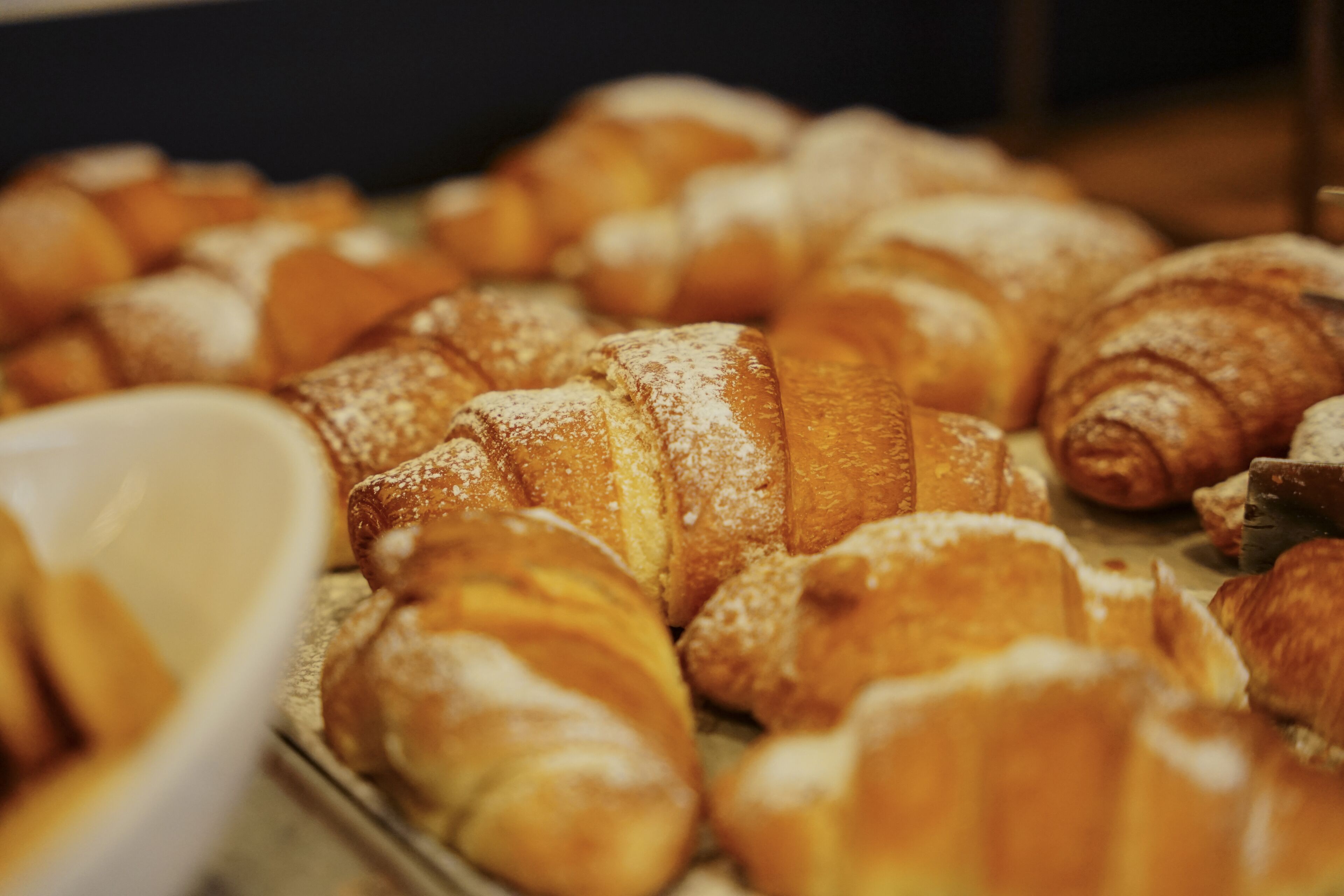 A variety of pastries, including croissants and other baked goods, displayed on a tray.