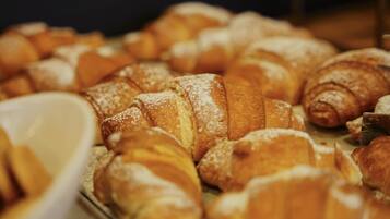 A variety of pastries, including croissants and other baked goods, displayed on a tray.