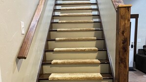 A staircase with wooden handrails and carpeted steps. - Cozy home with HOT TUB, River View & Fire Pit! (Garden Valley)