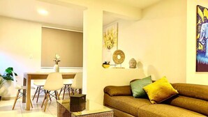 Un salon comprenant un canapé, une table basse et un coin repas avec des chaises et une table.