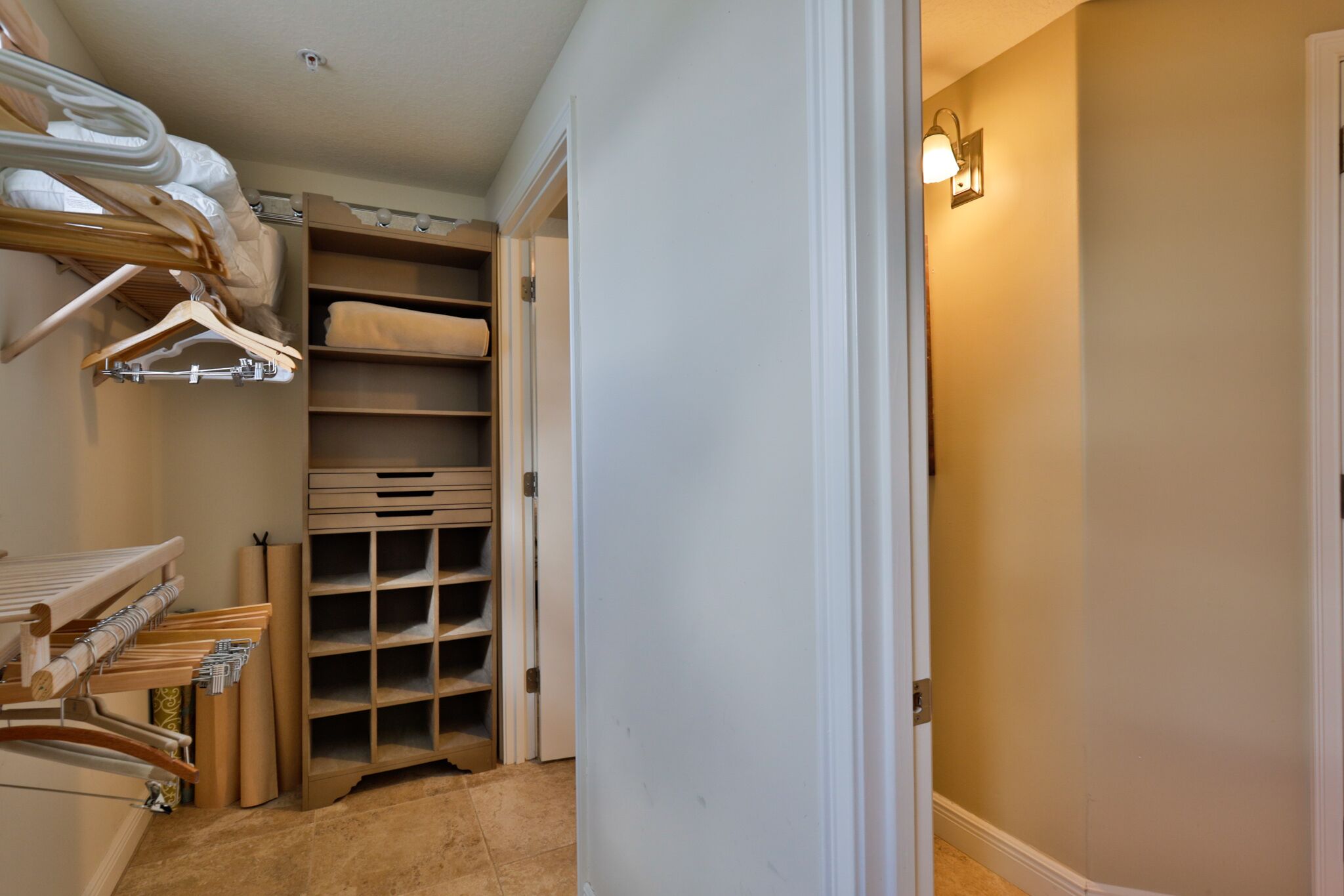 Um closet amplo com prateleiras e espaço para pendurar roupas, uma porta e um ponto de luz.