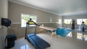 Ein großzügiges Fitnessstudio mit Laufband, Ergometer und verschiedenen Trainingsgeräten.