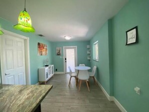 Cozy dining area with a wooden table and chairs, a white cabinet, and a hanging light fixture.