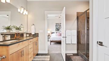 A modern bathroom with a vanity, mirror, and towel rack.