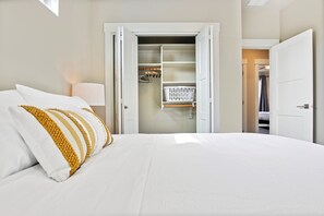 A hotel room with a bed, a wardrobe, and a closet with hanging clothes. - Top Rated Meridian Retreat • Clean & Spacious • Prime Central Location (Meridian)
