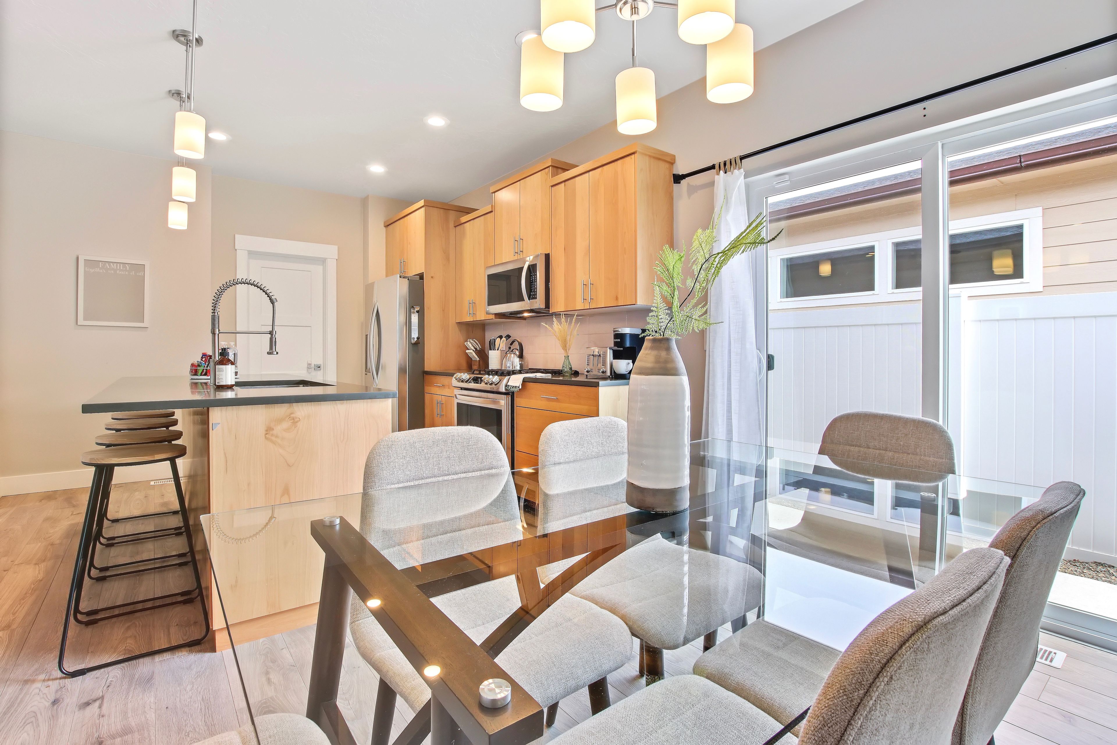 A modern kitchen with wooden cabinets, a stainless steel refrigerator, and a microwave.