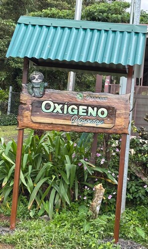 A wooden sign with the name "Oxígeno" and the word "Hovepage" underneath. - OXIGENO I  (Bijagua)