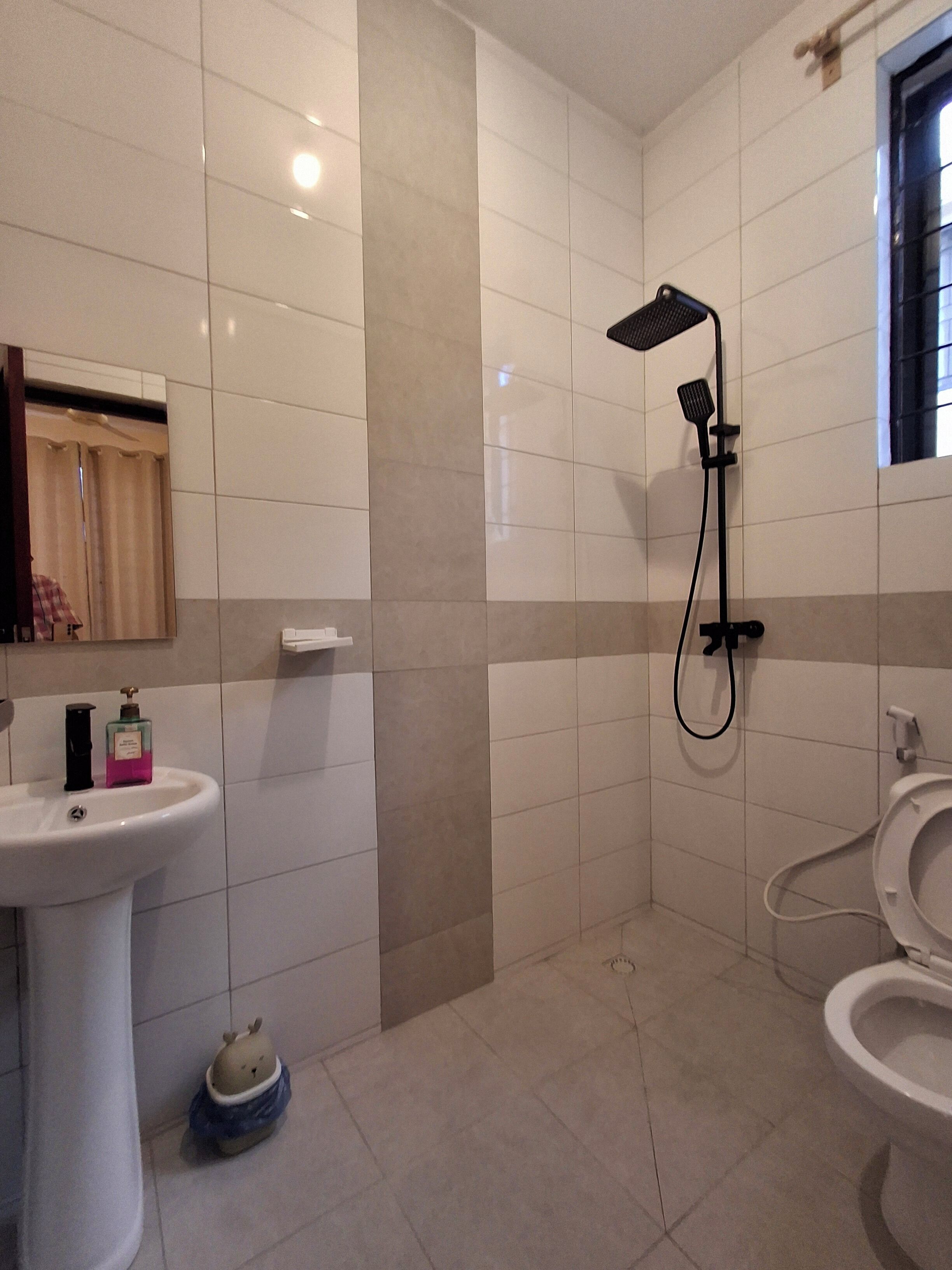 Une salle de bain équipée d’un lavabo, de toilettes, d’une douche et d’un porte-serviettes.