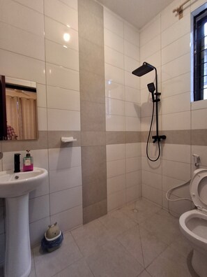 Ein Badezimmer mit Waschbecken, Toilette, Dusche und Handtuchhalter.