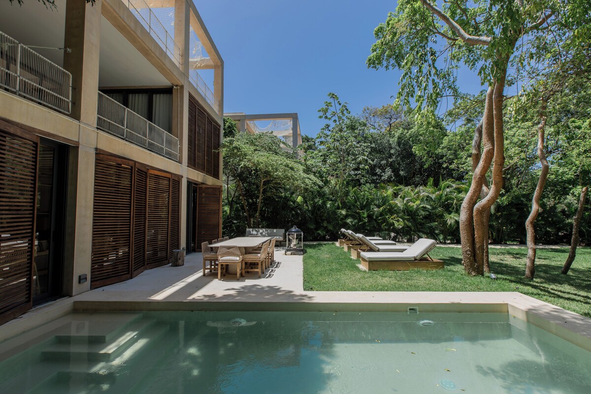 A modern outdoor pool area with a dining set and lounge chairs.