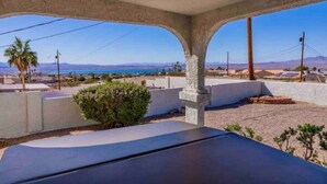 A covered outdoor area with a view of a coastal landscape, featuring a concrete structure with pillars and a flat roof. - Peaceful Desert Villa - Lake View, Pool & Spa (Lake Havasu City)