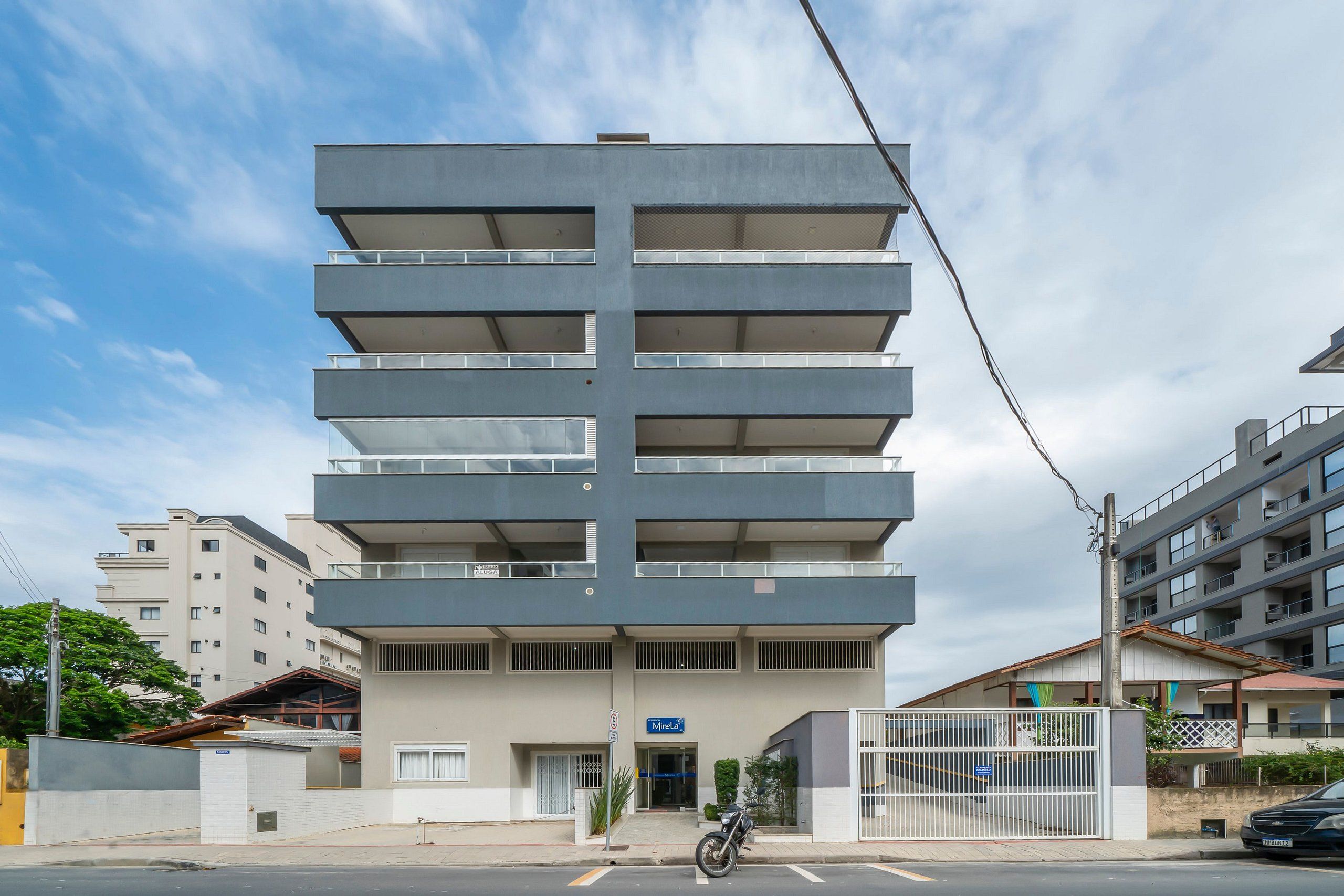Um edifício moderno de vários andares, com varandas em cada pavimento.