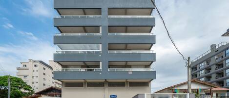 A multi-story building with a modern design, featuring balconies on each floor.
