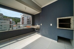 Varanda com vista para edifícios e uma montanha.