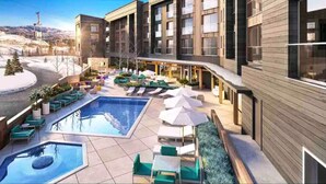 A modern hotel with a rooftop pool area, outdoor seating, and a view of the surrounding landscape. - Ski-in/Ski-out Canyon Haus Modern 1 bedroom- Pool, Hot Tub, Gym (Park City)