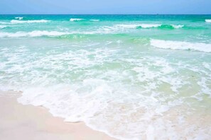A beach with waves gently lapping onto the shore. - Family Friendly • 5 Min Walk to Sand • Game Room • Long Term Stays • Dogs OK (Panama City Beach)