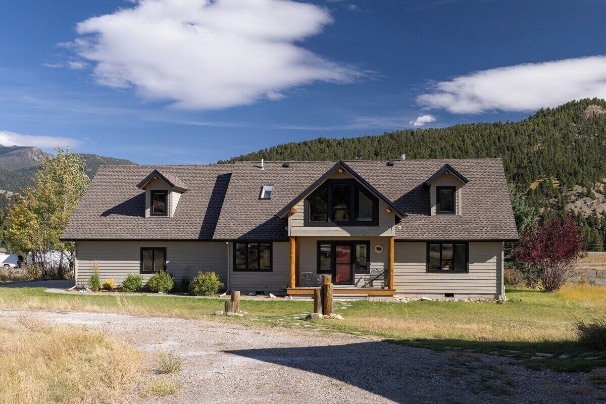 A two-story house with a gabled roof, a front porch, and a driveway.
