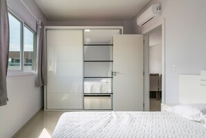 Een slaapkamer met een bed, een kledingkast en een raam.