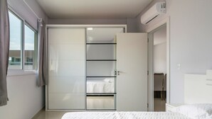 Een slaapkamer met een bed, een kledingkast en een raam.