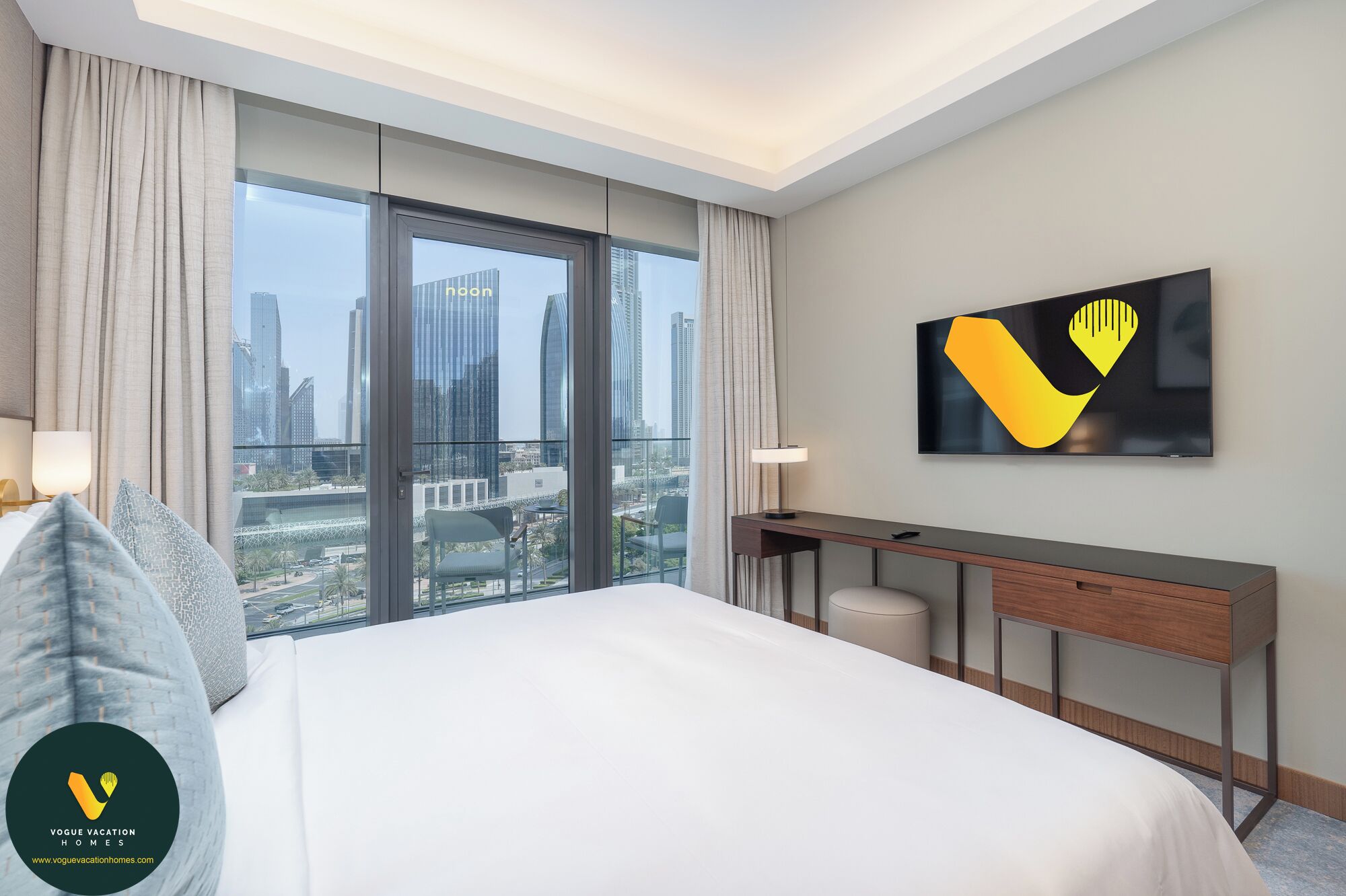 Quarto de hotel com uma cama grande, uma escrivaninha e vista para a cidade.