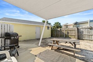 A covered patio area with a barbecue grill, picnic table, and outdoor seating. - Short Walk To Beach | Additional Studio (Panama City Beach)