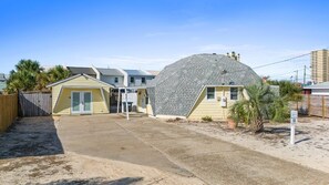 A residential area with a house featuring a unique dome-shaped roof, a small attached garage, and a concrete driveway. - Short Walk To Beach | Additional Studio (Panama City Beach)