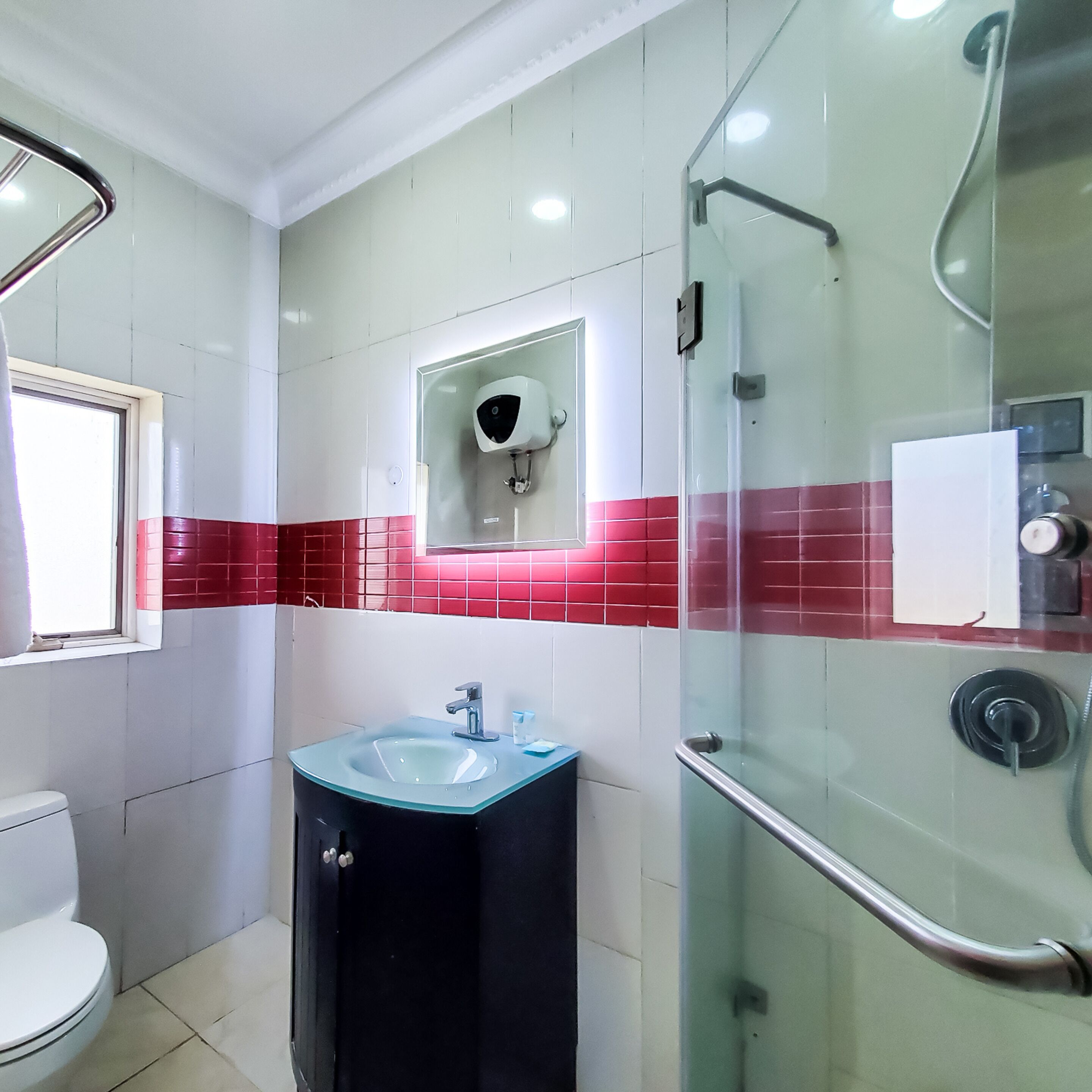 A bathroom with a toilet, a sink, and a shower area.