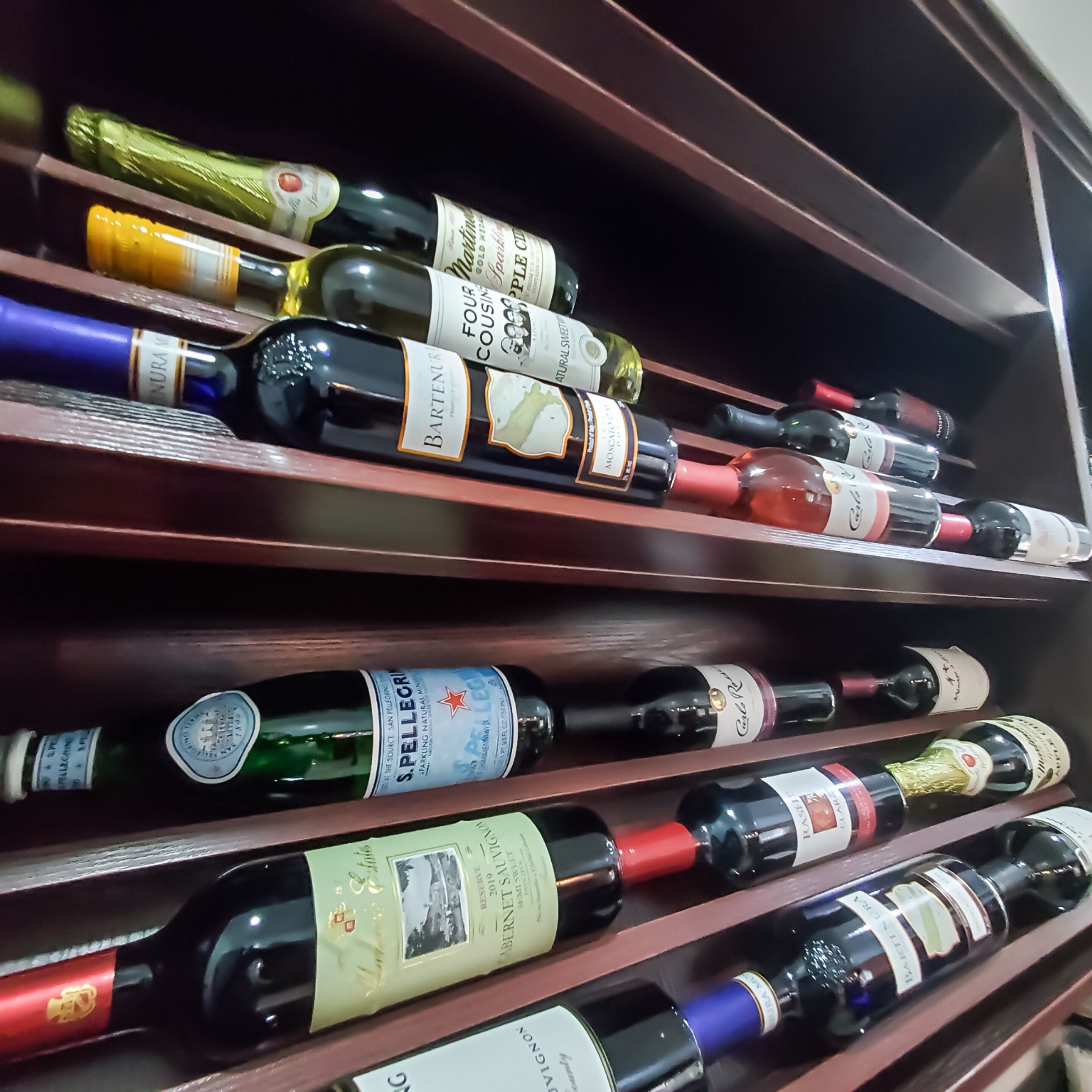 A wine rack with various bottles of wine.