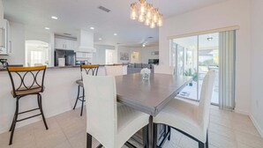 Una cocina moderna con comedor, una mesa grande y sillas.