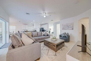Ein modernes Wohnzimmer mit einer Couch, einem Couchtisch und einem Fernseher.