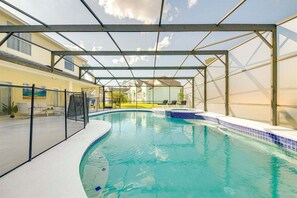 Ein überdachter Pool mit Blick auf ein Haus im Hintergrund.