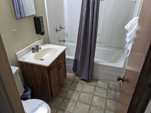 A bathroom with a sink, toilet, and bathtub.