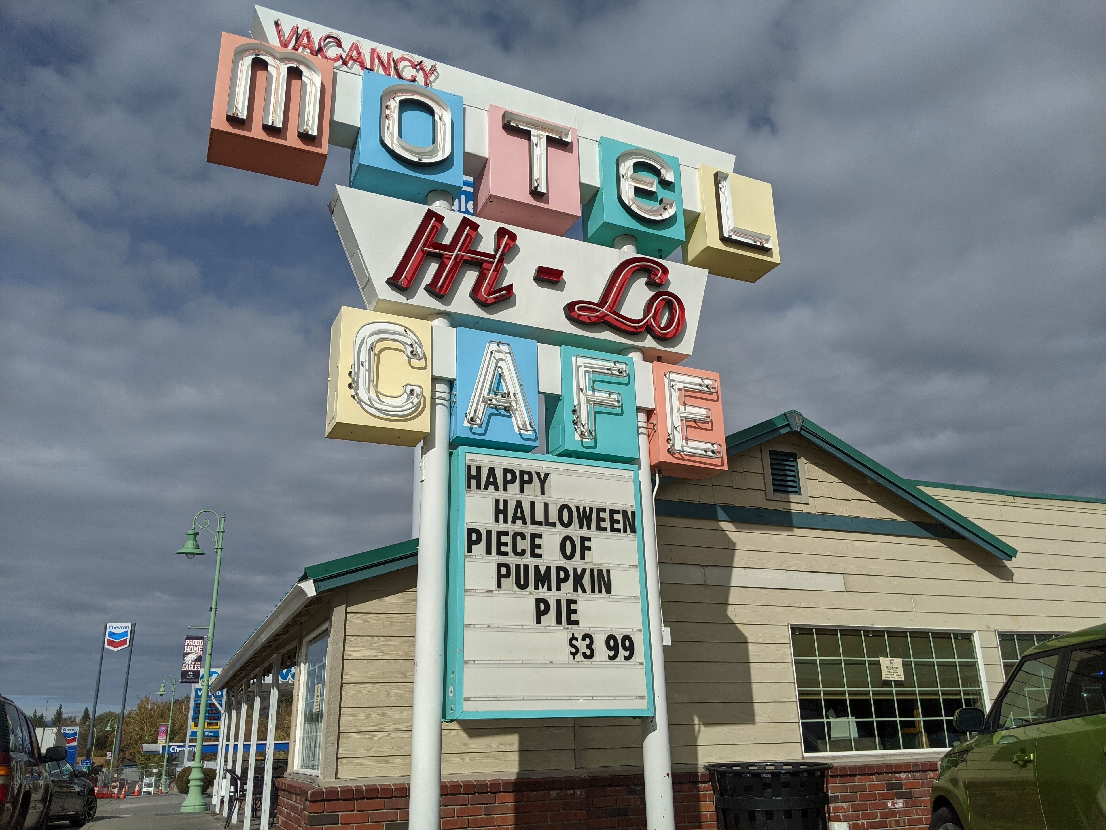 Un motel avec une enseigne au néon qui fait la publicité d’une tarte à la citrouille d’Halloween, au prix de 3,99 $.