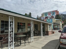 Un motel con terraza al aire libre, un cartel que indica disponibilidad y una cafetería.