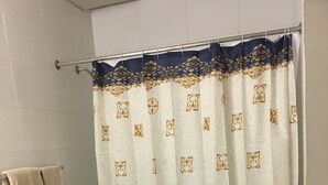 Een badkamer met toilet, wastafel en douchegordijn.