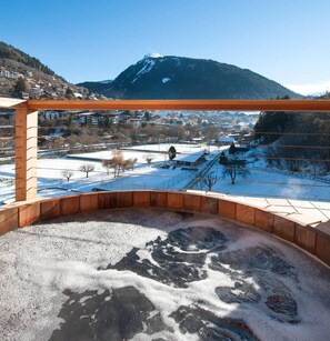 A view from a balcony with a wooden railing, overlooking a snowy landscape with houses and a mountain in the background. - Chalet, 70m from ski lifts, view mountain, swimming pool, sauna, fireplace or stove, parking, tv (Morzine)