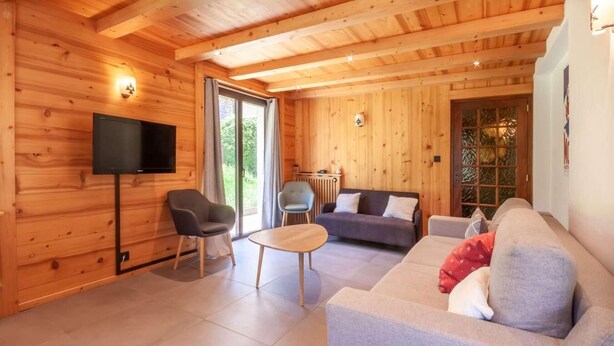 A wooden interior with a sofa, chairs, a TV, and a window. - 100m from ski slopes, Ground floor, terrace, parking, tv, ski locker, 67m², Morzine (Morzine)