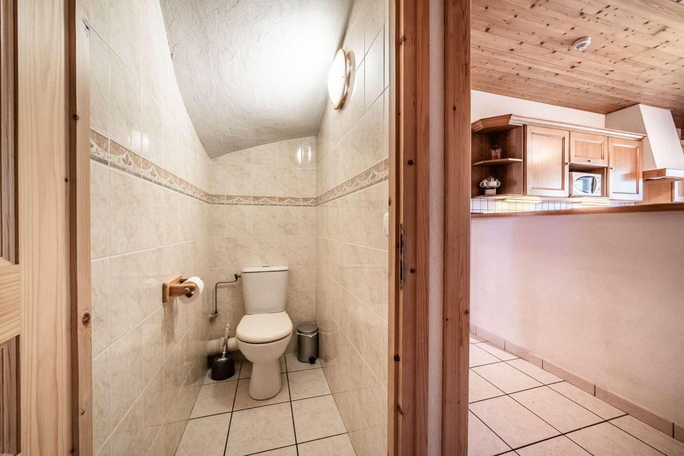 A bathroom with a toilet, a bidet, and a trash bin.