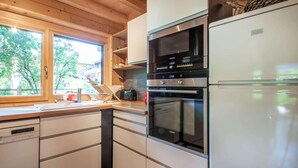 Een moderne keuken met witte kastjes, een roestvrijstalen oven en een inbouwmagnetron.