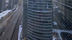 Un immeuble de grande hauteur doté d’une façade incurvée et d’une tour imposante.