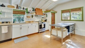 A modern kitchen with white cabinets, a stainless steel oven, and a built-in microwave. - Mount Dora Home: Private Pool & Tropical Bar! (Mt Dora)